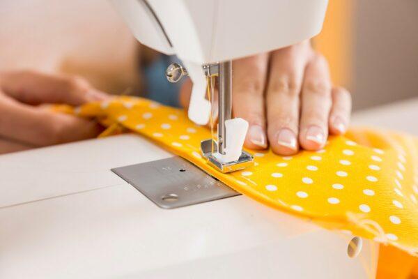 close-up-hands-sewing-with-machine_23-2148875360